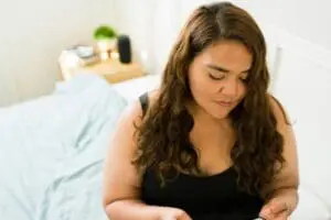 switching from mounjaro to wegovy | woman sat on bed looking down mildly concerned